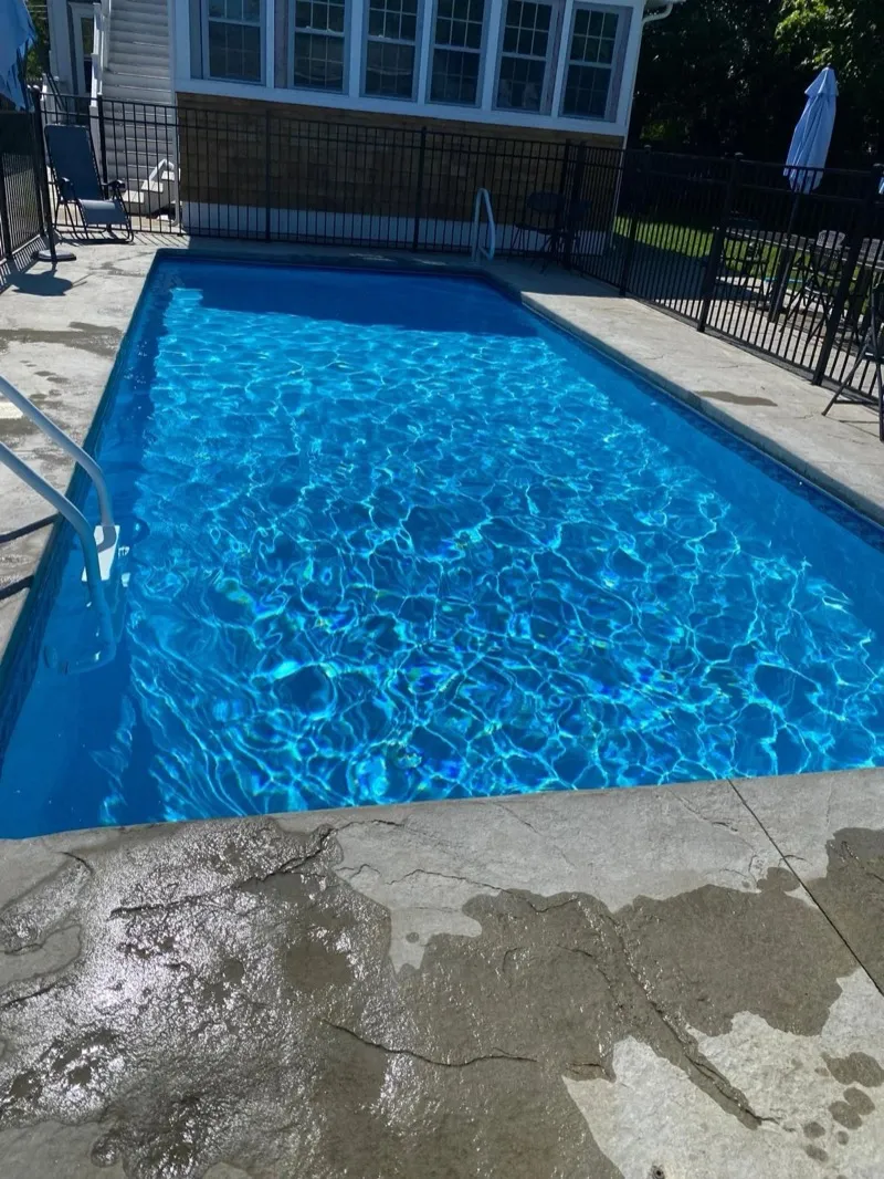 Sunlight rippling across the blue water of a freshly finished pool