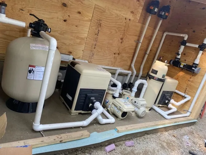 Sand filter, heater and pumps plumbed inside a plywood equipment shed